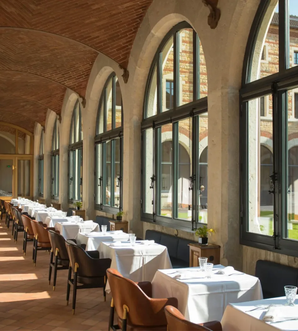 Salle à manger lumineuse avec grandes baies vitrées.