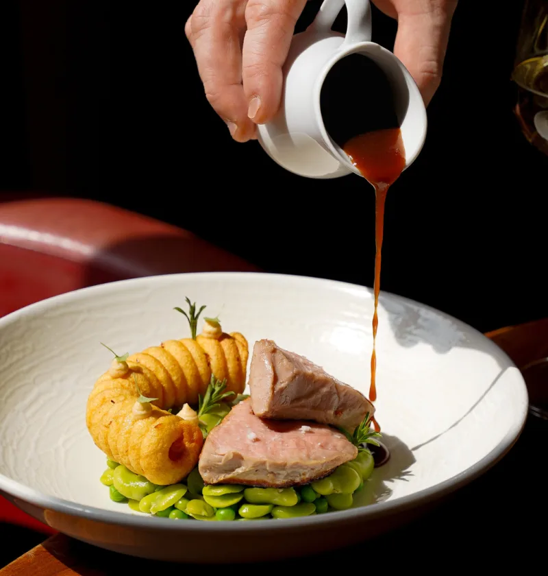 Plat gastronomique avec sauce versée, verre de vin.