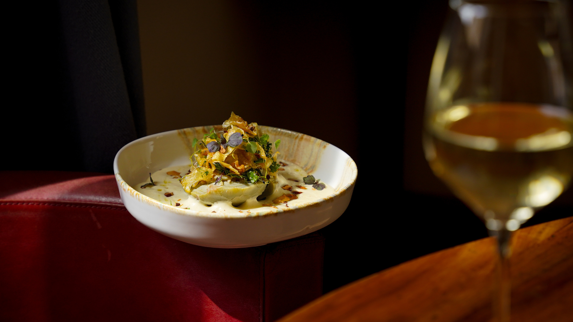 Plat gourmand avec verre de vin blanc.