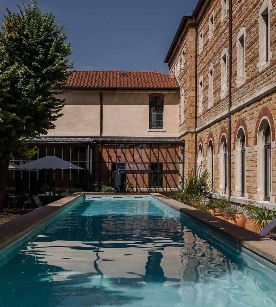 Piscine extérieure près d'un bâtiment en pierre.