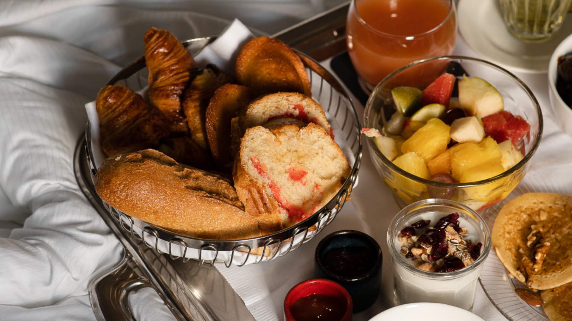 Petit-déjeuner varié avec viennoiseries et fruits.